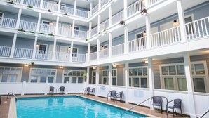 Una piscina interior de varios niveles con techo de cristal, múltiples balcones y zonas de estar.