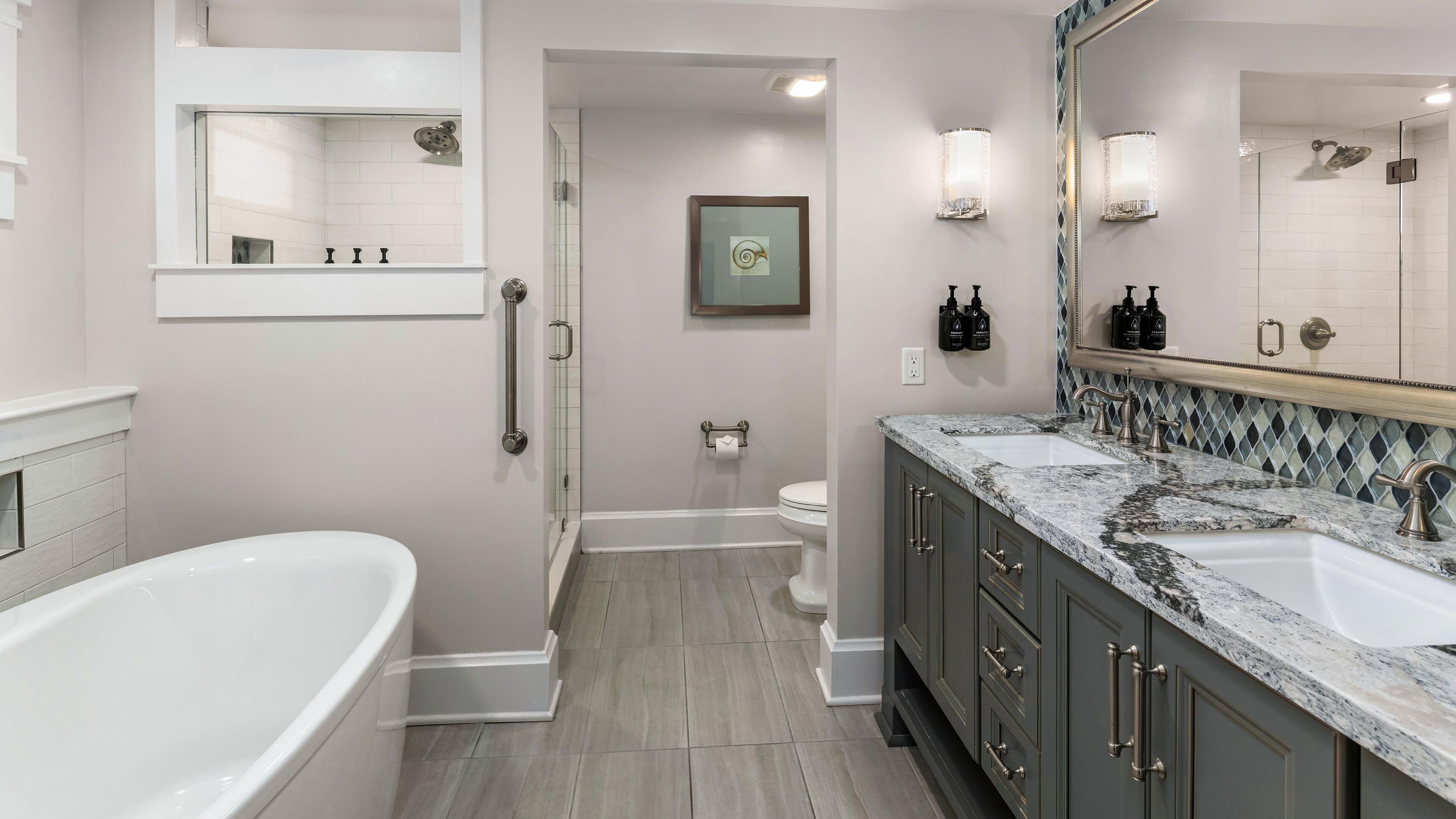 A modern bathroom with a bathtub, a sink, a toilet, and a shower.