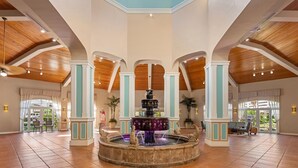 A spacious lobby with a central fountain, high ceilings, and large windows. - Holiday Inn Club Vacations Cape Canaveral Beach Resort by IHG (Cape Canaveral)