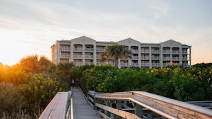 A hotel with a wooden boardwalk leading to a building with multiple balconies. - Holiday Inn Club Vacations Cape Canaveral Beach Resort by IHG (Cape Canaveral)