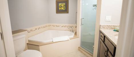 Ein Badezimmer mit Badewanne, Toilette und Duschbereich.