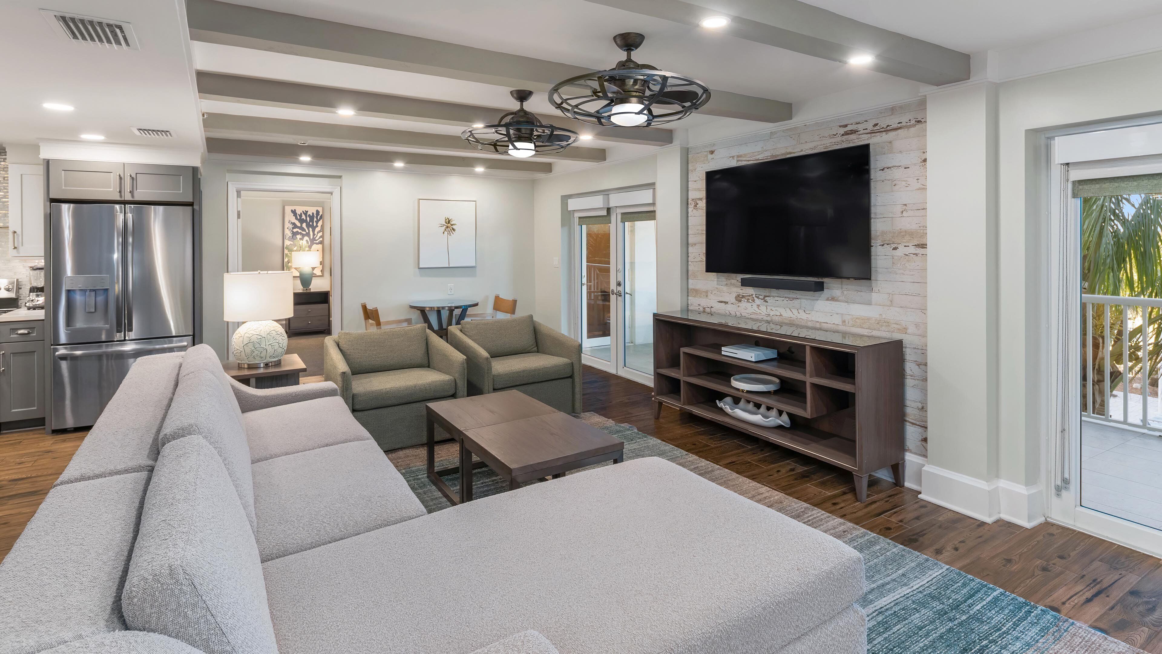 A modern living room with a sectional sofa, a flat-screen TV, and a built-in entertainment unit.