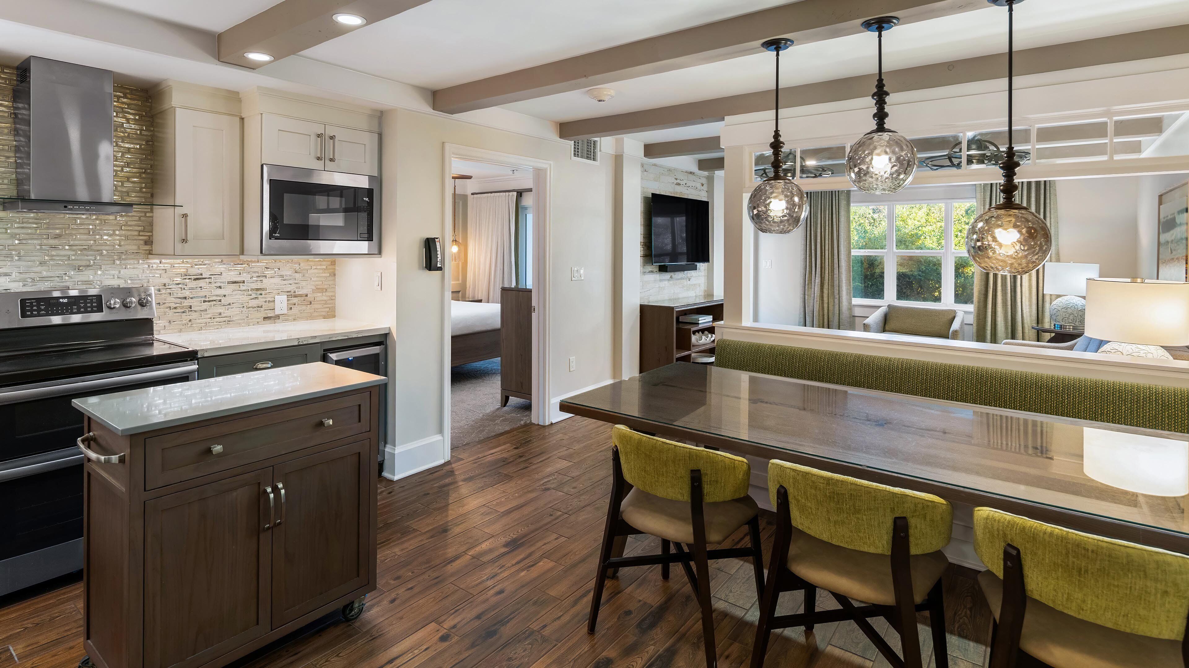 A modern kitchen with a central island, wooden cabinets, and a built-in microwave.
