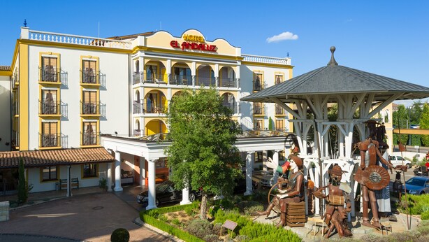 A hotel with a central courtyard, a gazebo, and outdoor statues.