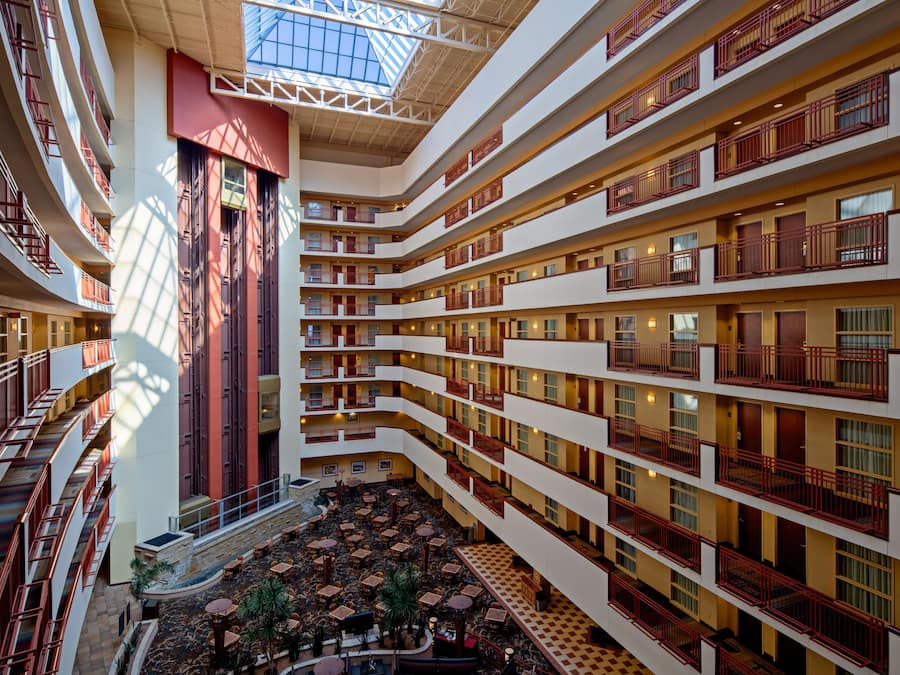 A multi-level hotel interior with a central atrium, balconies, and a dining area.