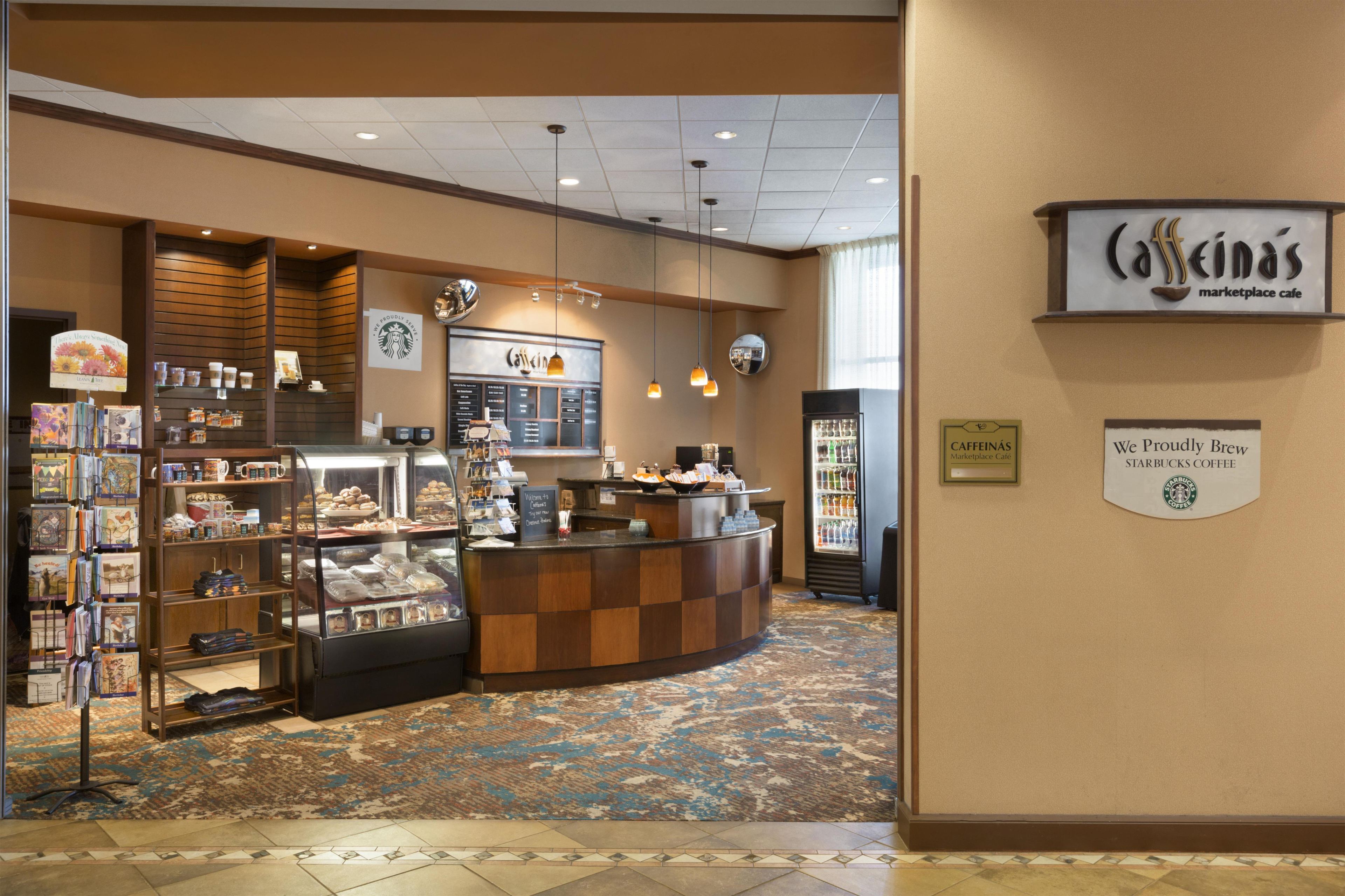 Um Starbucks Marketplace Café com balcão, vitrines e diversas opções de comida.