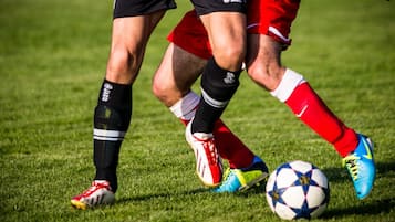 A close-up of soccer players in action, focusing on their legs and shoes.