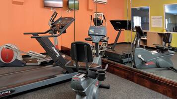 A gym with various exercise equipment including treadmills, stationary bikes, and a rowing machine.