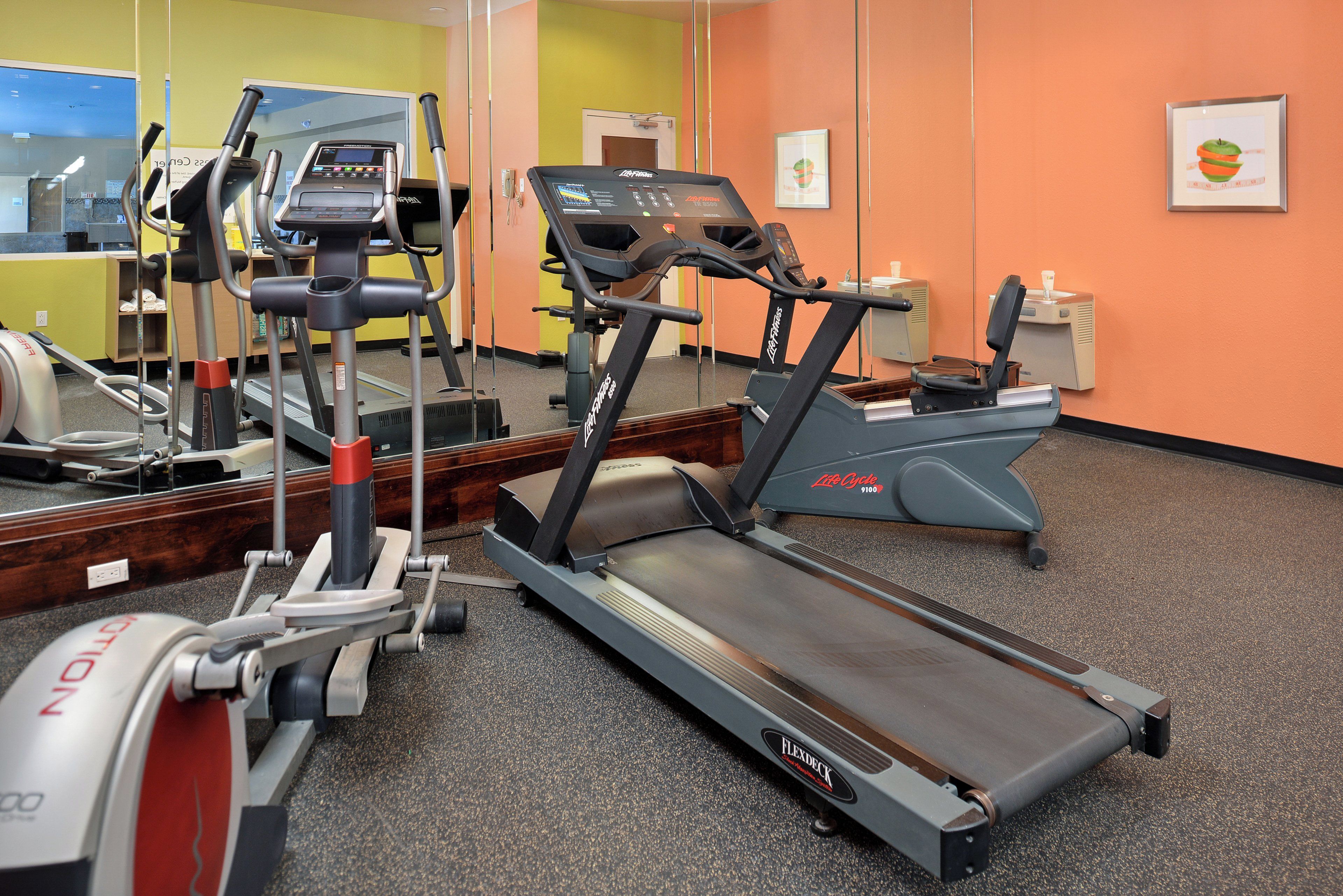 Et fitnesscenter med løbebånd, motionscykler og træningsudstyr.