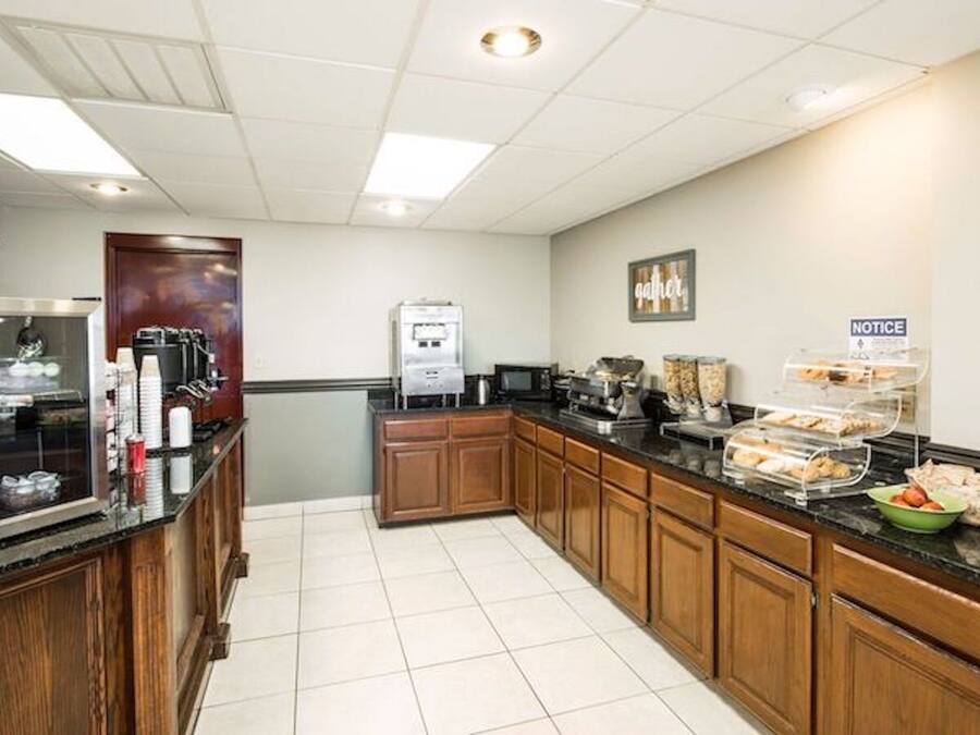 A hotel kitchen with a coffee station, a refrigerator, and a notice board.