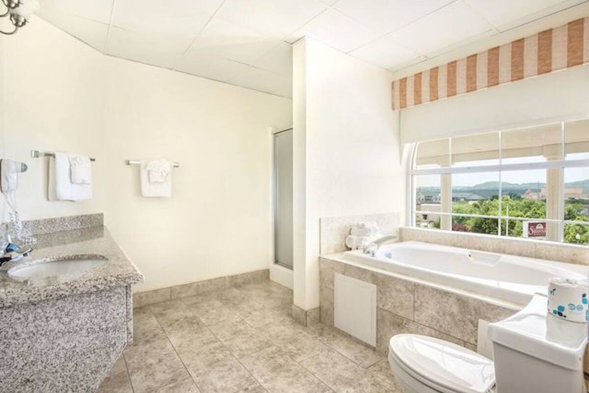suite, jetted tub | bathroom amenities | combined shower/bathtub, hair dryer, towels