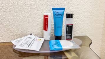 Una variedad de productos de cuidado personal sobre una superficie de vidrio transparente.