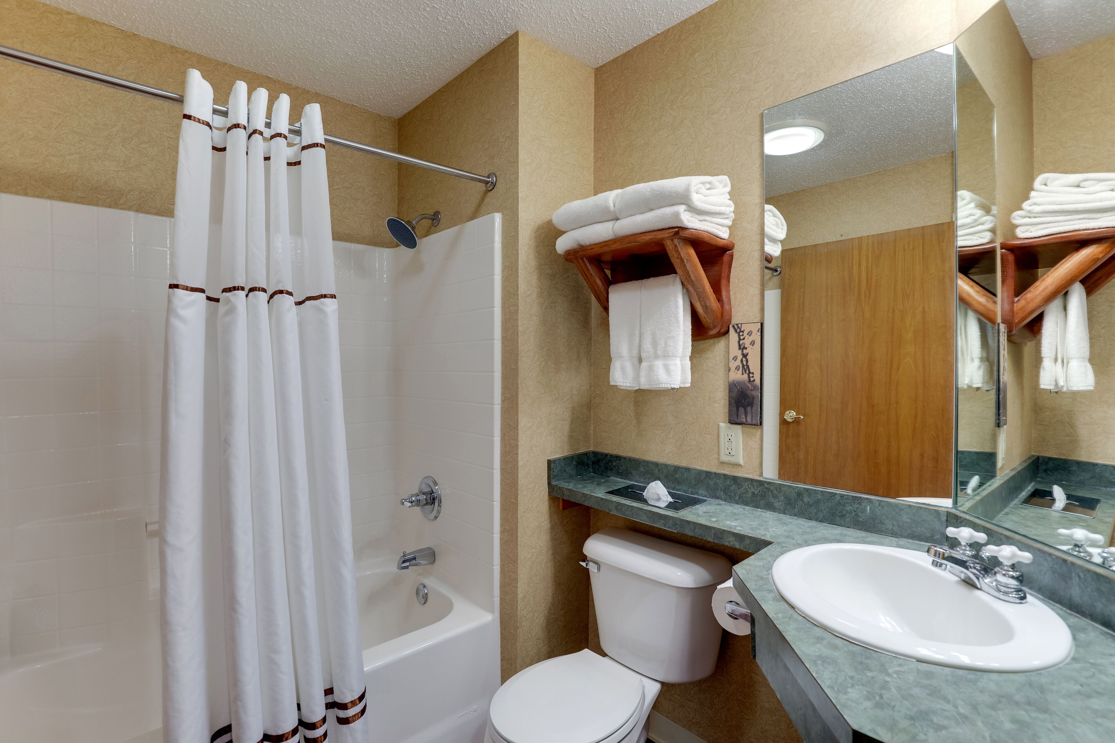 Un baño con bañera, inodoro, lavabo y espejo.