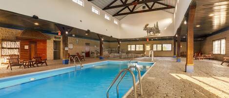 Ein Innenpool mit Steinböden, hölzernen Bänken und rustikalem Interieur.