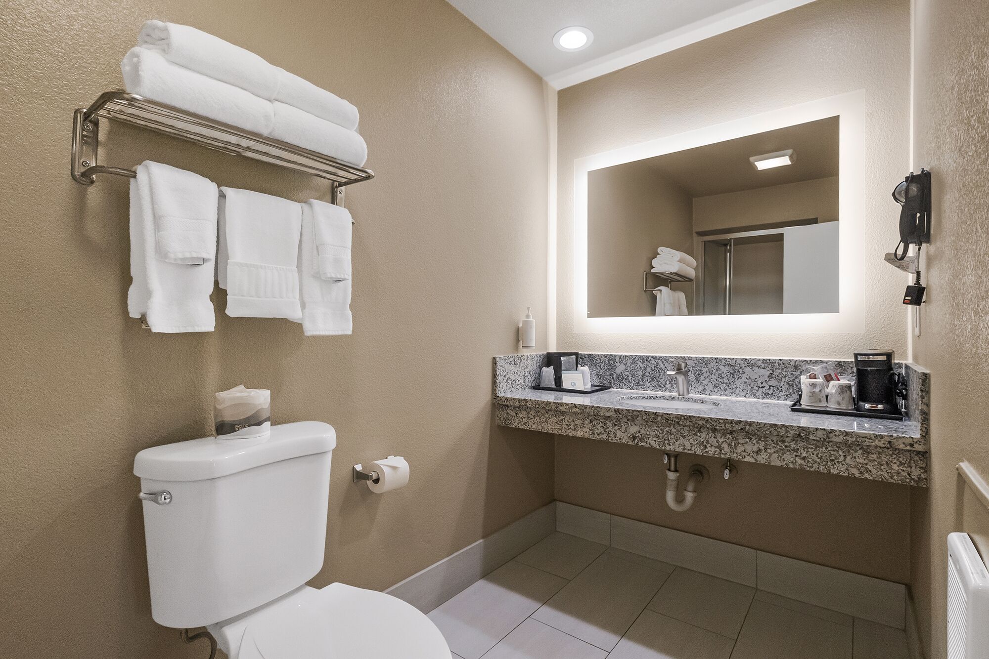 A bathroom with a toilet, sink, and towel rack.