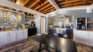 A modern kitchen with wooden beams, a large map, and a dining area with a table and chairs. - Comfort Inn near Hearst Castle - Cambria (San Simeon)