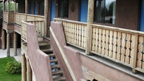 A building with a series of balconies and a staircase leading to the upper floors. - Sun God Lodge (Taos)