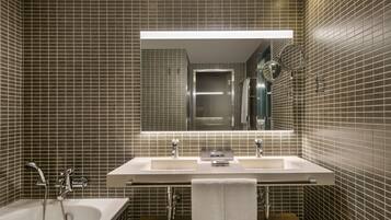 Un baño moderno con un lavamanos grande, una bañera y un espejo sobre el lavamanos.