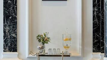 A wall-mounted sign reading "AUTOGRAPH COLLECTION" above a display table with a vase and glasses.