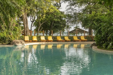 Una piscina al aire libre, sillones reclinables de piscina