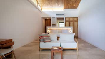A modern living room with a wooden ceiling, a white sofa with cushions, a small wooden table, and a ceiling fan.