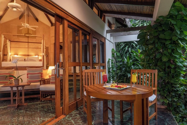 A wooden dining table with chairs, a bench, and a glass of orange juice.