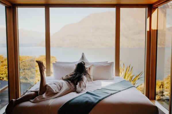 A bedroom with a large window overlooking a body of water and mountains. - Azur Luxury Lodge (Queenstown)