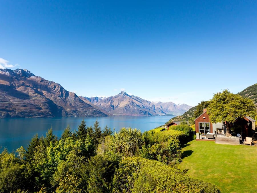 Una casa con vistas a montañas y un lago.