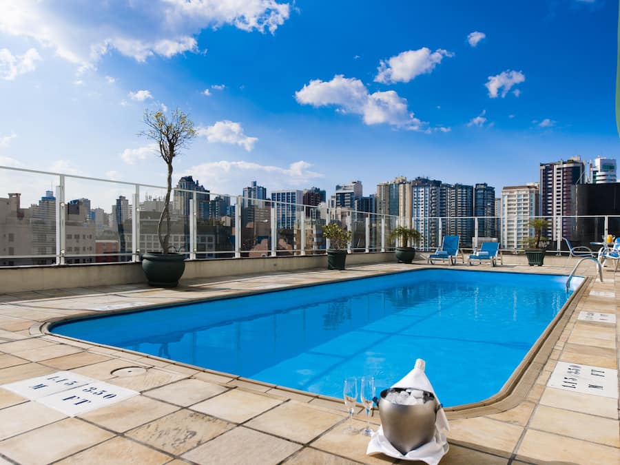 Una piscina al aire libre, sillones reclinables de piscina