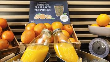 Un bar à jus où l’on propose des oranges fraîches et des bouteilles de jus d’orange.
