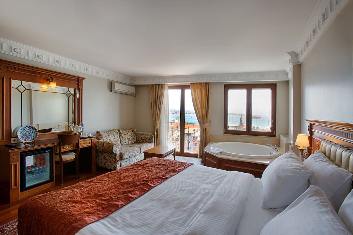 Habitación superior, 1 cama King size y sofá cama, hidromasaje, vista al mar | Ropa de cama de alta calidad y minibar