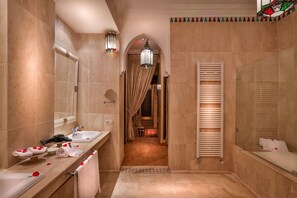 A luxurious bathroom with a double sink, a large mirror, a shower with a glass door, and a towel rack.