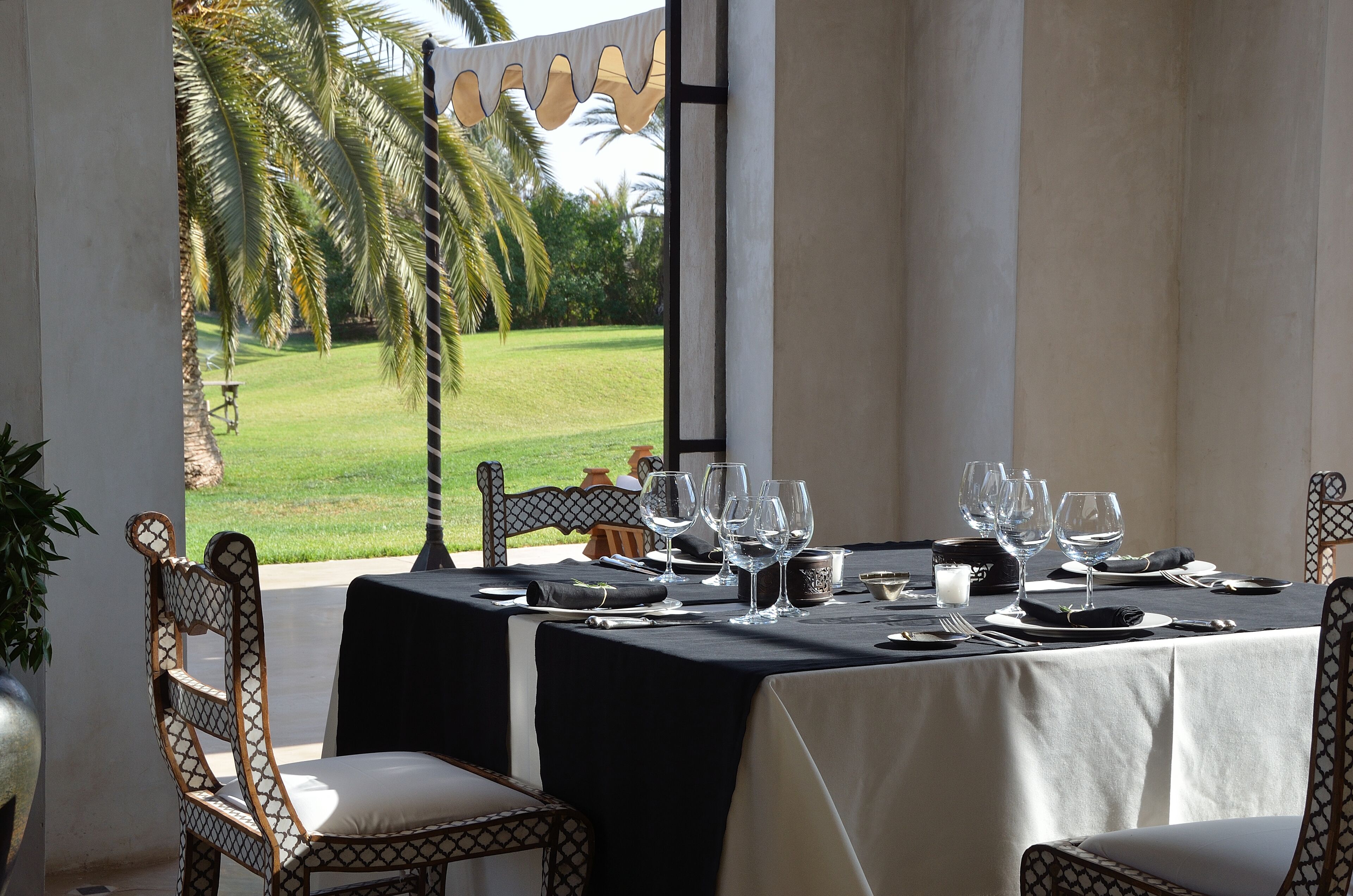 A dining table set with chairs, a view of a golf course, and a large window.