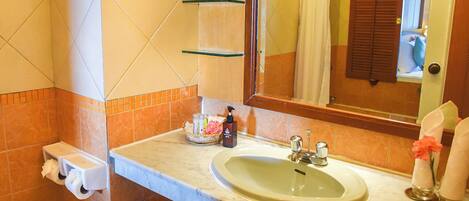 A bathroom with a sink, mirror, and toiletries.