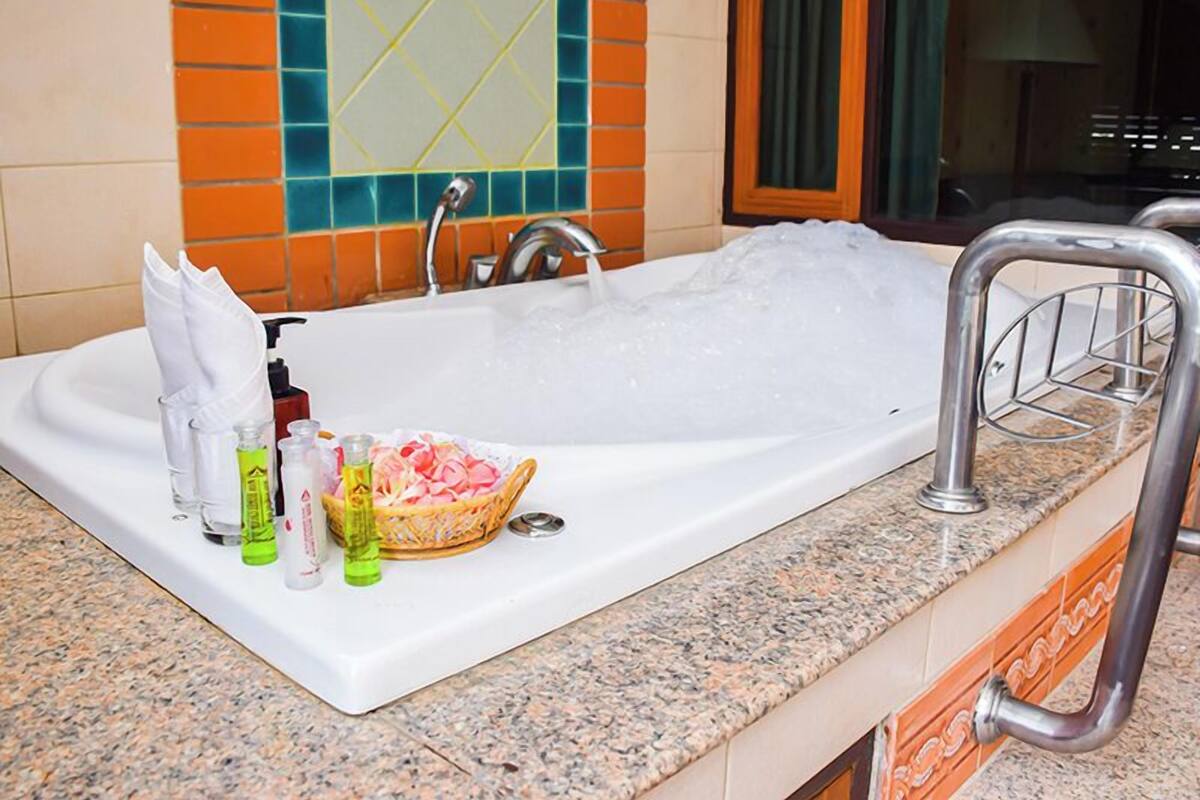 A bathroom with a bathtub, a sink, and toiletries on the counter.
