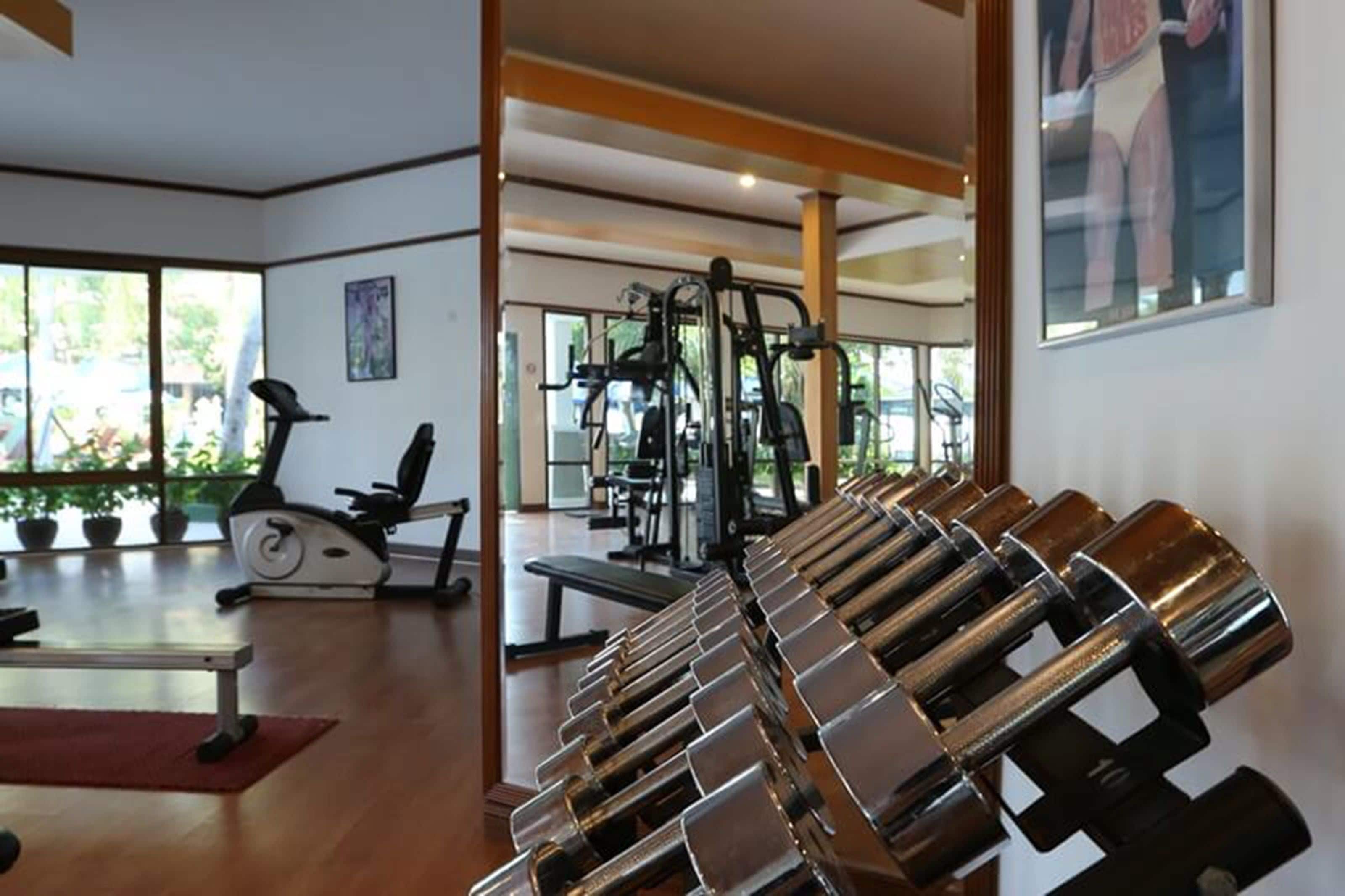 Een fitnessruimte met trainingsapparatuur, een loopband en een bank.