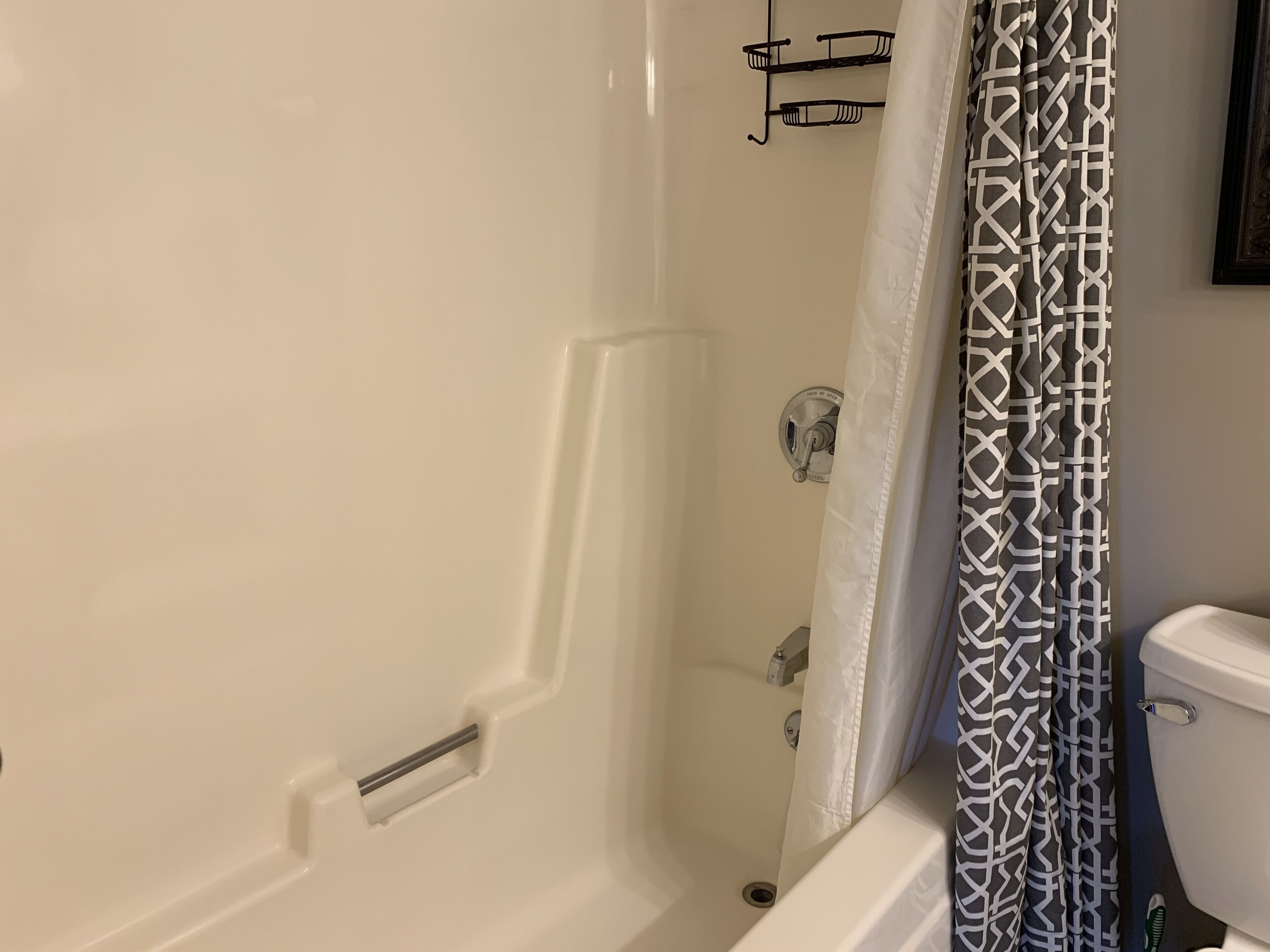 Une salle de bain avec une baignoire, des toilettes et un rideau de douche.