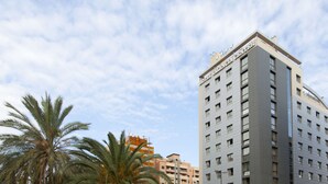 A multi-story hotel building with a modern architectural design, featuring a prominent sign at the top.