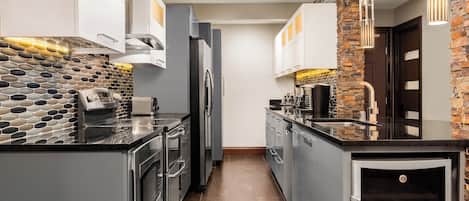 Una cocina moderna con protector de piedra, electrodomésticos de acero inoxidable y horno empotrado.