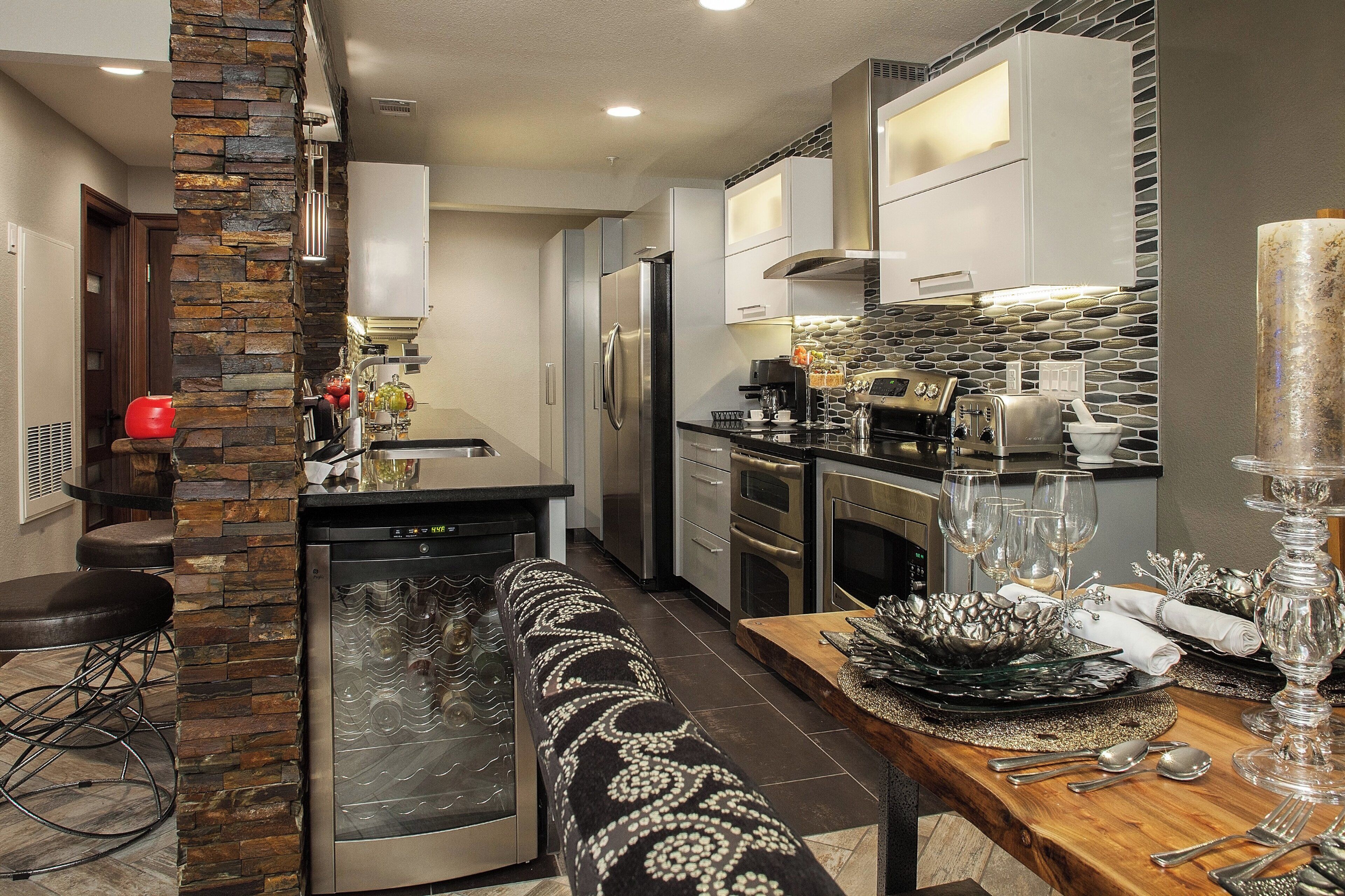 A modern kitchen with a built-in dishwasher, stainless steel appliances, and a dining area with a glass-top table.