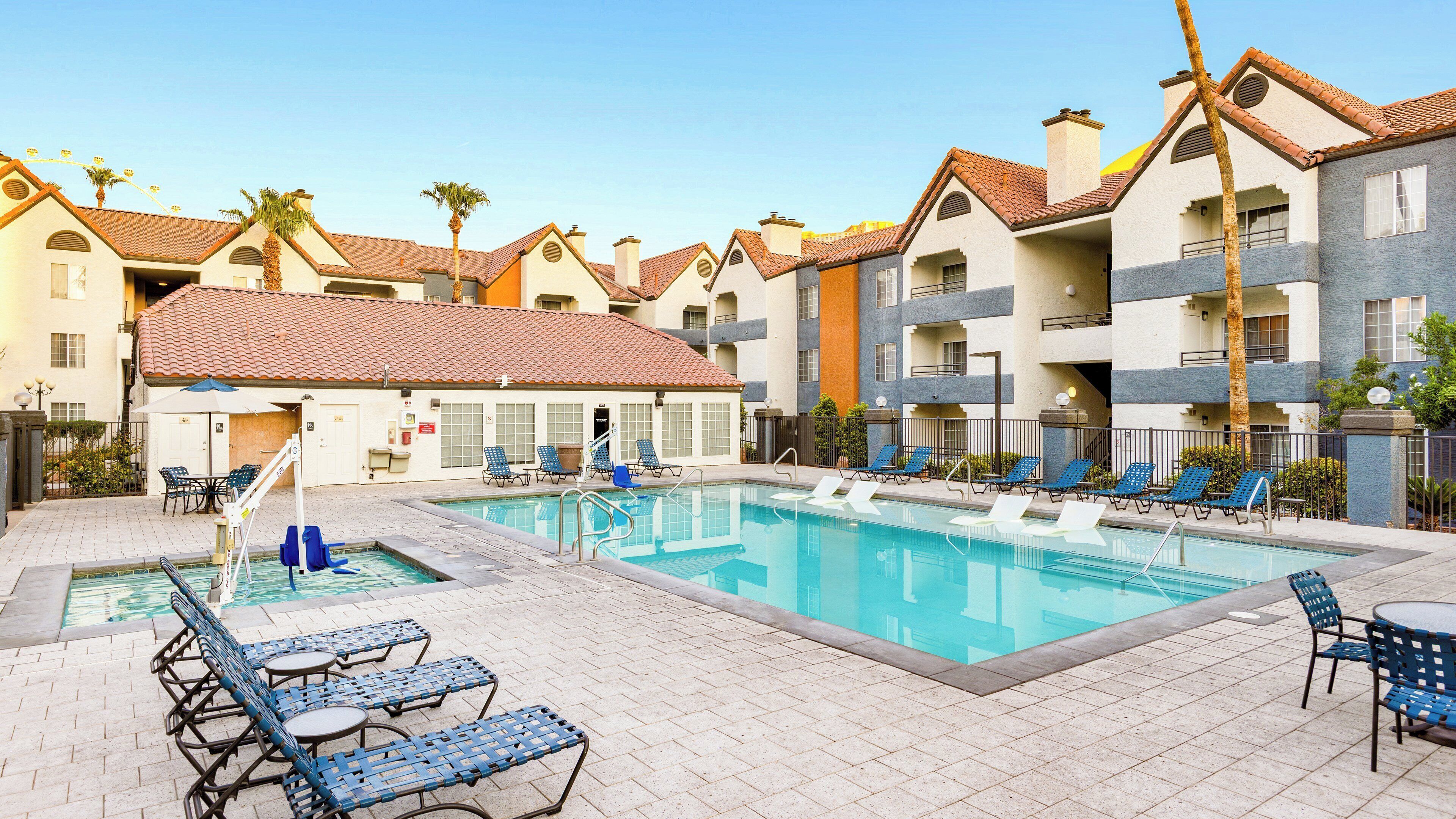 A swimming pool area with lounge chairs and a small pool table.