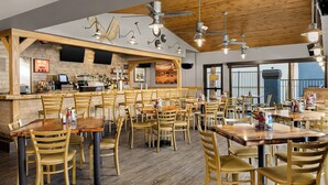 A restaurant with wooden furniture, a bar area, and a view of the sea. - Holiday Inn Club Vacations at Desert Club Resort by IHG (Las Vegas)