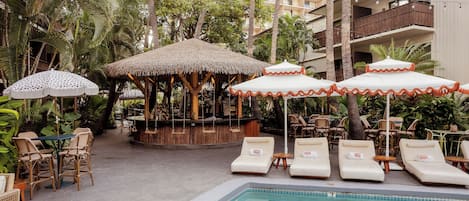 A poolside area with lounge chairs, umbrellas, and a bar area.