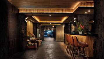 A bar area with stools, a counter, and a view of the city in the background.