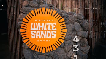 A sign for Waikiki White Sands Hotel, featuring a circular design with the hotel's name and address.