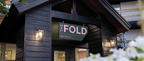 Un edificio con un letrero que dice "The Fold Hotels" y una entrada visible con puertas de cristal.
