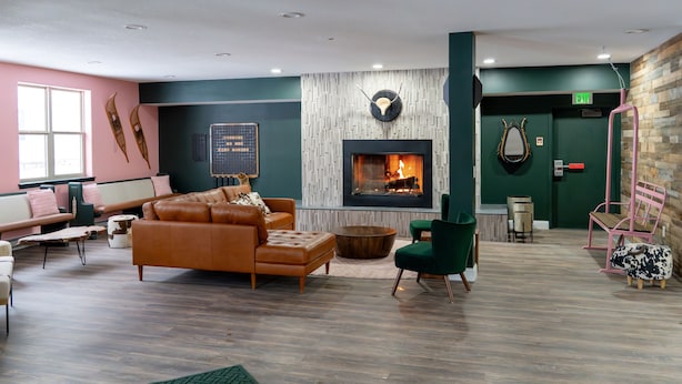 Ein moderner Lounge-Bereich mit Kamin, Sitzgelegenheiten und Holzboden.