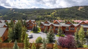 Eine Lodge mit mehreren Blockhütten, umgeben von bewaldeten Hügeln und Bergen.