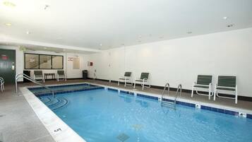 Relax by the pool surrounded by comfortable lounge chairs and a metal ladder for easy access.