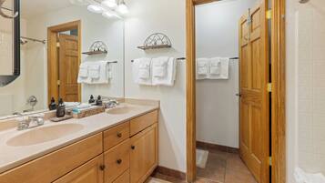 A bathroom with two sinks, a mirror, and a wooden door.